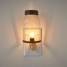 a mason jar wall light with a candle on the front and side lights above it