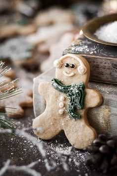 a close up of a cookie shaped like a snowman next to some pine cones