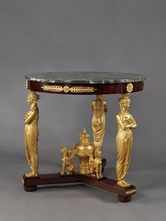 an antique table with statues on it