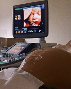 a computer monitor sitting on top of a desk next to a keyboard and remote control