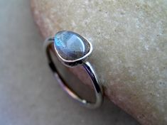 This drop shaped Labradorite ring has such a brilliant deep blue flash with hint of gold and green running through. This iridescent stone is hand set into a sterling silver bezel.The stone is approximately 10mm x 6mm.Labradorite is a stone of (self) empowerment, inspiring confidence and enthusiasm. It's healing properties include a calming and harmonizing effect. Will come beautifully gift wrapped. Stackable Sterling Silver Teardrop Jewelry, Adjustable Teardrop Moonstone Ring In Sterling Silver, Silver Pear-shaped Moonstone Jewelry, Silver Teardrop Stackable Jewelry, Silver Solitaire Teardrop Ring, Silver Stackable Teardrop Jewelry, Silver Labradorite Drop Jewelry, Minimalist Teardrop Jewelry With Bezel Setting, Minimalist Teardrop Bezel Set Jewelry