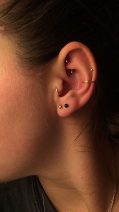 a close up of a person with ear piercings on their ears and one behind the ear