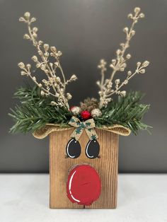 a wooden box with some plants in it and a reindeer face on the front side