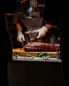 a chef is cutting up some meat on a wooden board