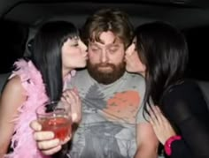 three women and a man kissing in the back of a car