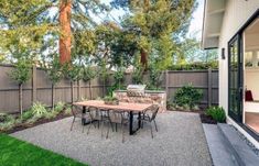 a backyard with a table and chairs in it