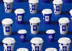 many cups are lined up on a blue surface