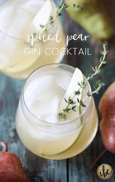 two glasses filled with gin cocktail on top of a wooden table