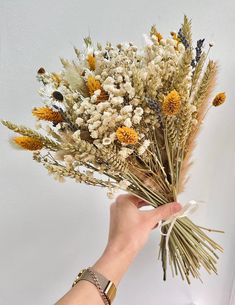 a person is holding some dried flowers in their hand