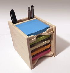 a wooden desk organizer with pens and markers