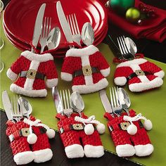 a table topped with silverware covered in santa clause hats and holding utensils