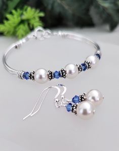 This white pearl bracelet can be gifted as bridesmaid jewelry for your entire bridal party, and can be purchased with or without matching earrings! Custom sapphire and pearl earrings is perfect for the bride as well for her "something blue"!  ABOUT THIS ITEM: * 8mm white austrian crystal pearls * 4mm sapphire austrian crystals * sterling silver bead caps * silver plated tube beads * pewter lobster claw clasp SHIPPING: * RUSH ORDERS can be purchased from the link below👇 https://www.etsy.com/shop/beadedjewelryforyou?ref=seller-platform-mcnav§ion_id=42024292 * Processing time is 3-5 business days * Each item is carefully packed by me in my studio presented in an Organza pouch. Bubble envelopes are used to ensure your item is protected * When item ships you will receive an email with tracking