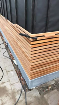 a large wooden planter sitting on top of a cement floor next to a building