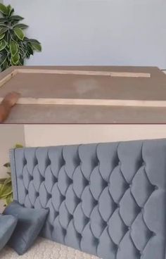 a bed that has been made into a headboard and is next to a potted plant