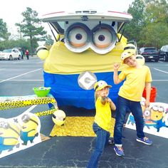 two young children standing in front of a fake minion