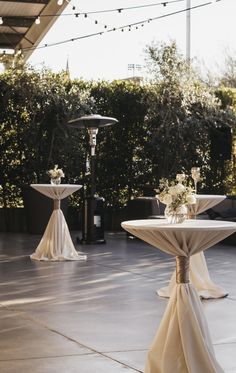 the tables are covered with white tablecloths and decorated with flower centerpieces