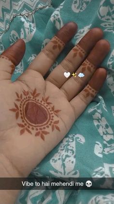 a person's hand with hendi on it and two hearts painted on the palm