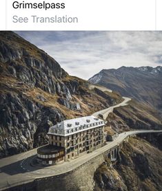 an aerial view of a building on the side of a mountain with mountains in the background