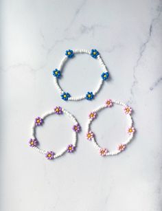 These cheerful floral bracelets are perfect for spring and summer! They're made with an elastic cord that allows them to easily slip on and off. This style is made from white beads with a multi flower detail. If you need a different size or would like to customize the colors, just message me! Matching rings available! https://www.etsy.com/listing/998861261/beaded-flower-ring-flower-seed-bead-ring?ref=shop_home_recs_4&crt=1 Adjustable White Bracelet With Flower Decoration, White Bohemian Bracelets For Spring, White Bohemian Bracelet For Spring, Spring Bracelets With Adjustable Flower Decoration, White Beaded Bracelets With Flower Charm For Spring, Adjustable Bracelet With Flower Decoration For Spring, Adjustable Flower Bracelets For Spring, Adjustable Spring Bracelet With Flower Decoration, Spring White Beaded Bracelets With Flower Charm