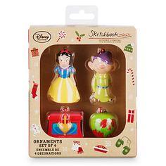 two toy figurines are in a box on a white background, one is wearing a yellow dress and the other has a red hat