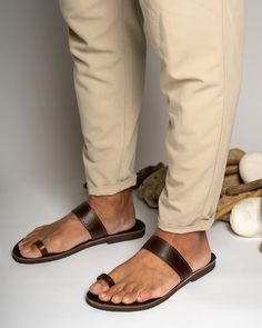 Men's handmade leather sandals in brown color are a stylish and functional choice for any occasion. Made from high-quality leather, these sandals are durable and comfortable to wear. The intricate detailing and design work add a touch of elegance to the overall look of the sandals.  All of our products are handmade with the best and highest quality leather from our beloved island of ''Crete''.  The leather used for each item may be irregular in terms of colour and texture due to its natural char Brown Toe Loop Sandals With Leather Footbed, Brown Toe Ring Sandals With Leather Footbed, Men Leather Sandals Fashion, Leather Sandals Men, Men Leather Sandals, Handmade Leather Sandals, Ring Leather, Mens Shoes Sandals, Leather Sandals Handmade