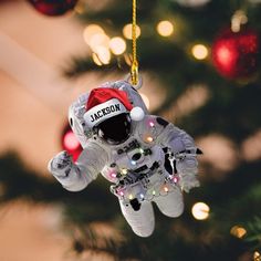 an astronaut ornament hanging from a christmas tree