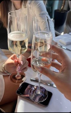 two people holding up wine glasses at a table