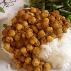 a white plate topped with rice and beans next to green beans on top of it