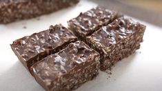 several pieces of chocolate brownie sitting on top of a white counter