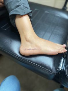 a person with a tattoo on their foot is sitting in a chair and has the word love written on it