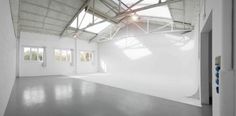 an empty room with white walls and windows