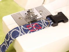 a sewing machine with a blue and white tie on it's belt that has a red triangle in the center