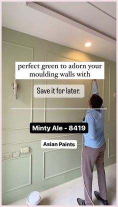 a man is painting the walls in his living room with white paint and an ad for minty ale