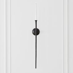 a white door with a black handle and a candle in the middle on it's side