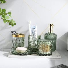 green glass bathroom accessories sitting on a counter