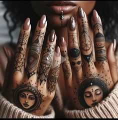 a woman's hands with tattoos on them holding her hands in front of her face