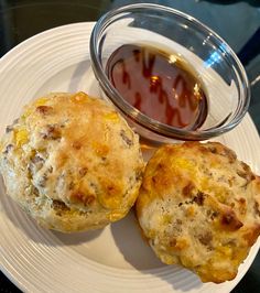 two muffins on a plate with dipping sauce