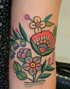 a woman's arm with flowers and leaves painted on the back of her leg