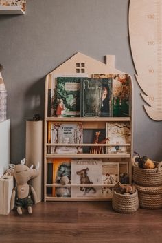 a bookshelf filled with lots of books on top of a wooden floor