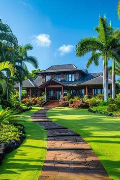 a large house surrounded by palm trees and lush green lawns on a sunny day