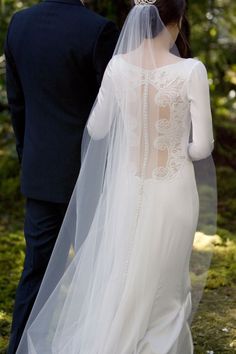 the back of a bride's wedding dress and veil