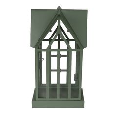 a green house shaped bird feeder on a white background