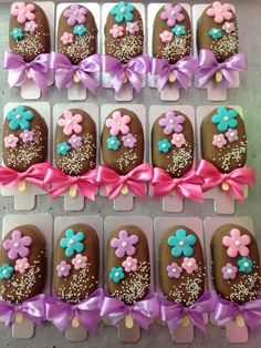 chocolates decorated with flowers and bows are arranged in rows