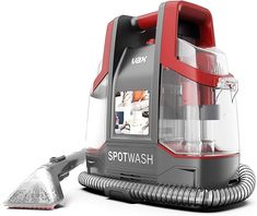 a red and gray steam washer sitting on top of a white table next to a dust collector