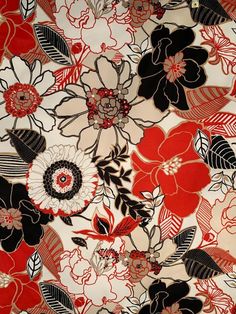 a red and black floral print fabric with leaves, flowers, and petals on it