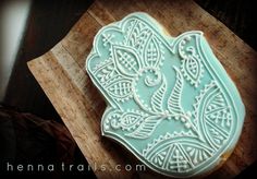 an intricately decorated cookie sits on a cutting board