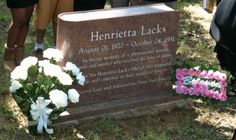 two people standing next to a memorial with flowers