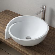 a white bowl sink sitting on top of a wooden counter