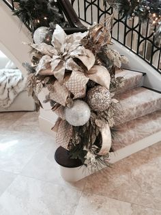 a bunch of christmas decorations sitting on top of a set of stairs next to a banister