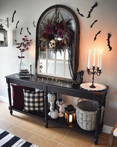 a black console table with candles and decorations